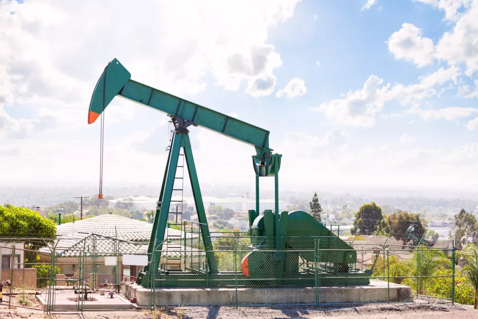Green oil well in California neighborhood.